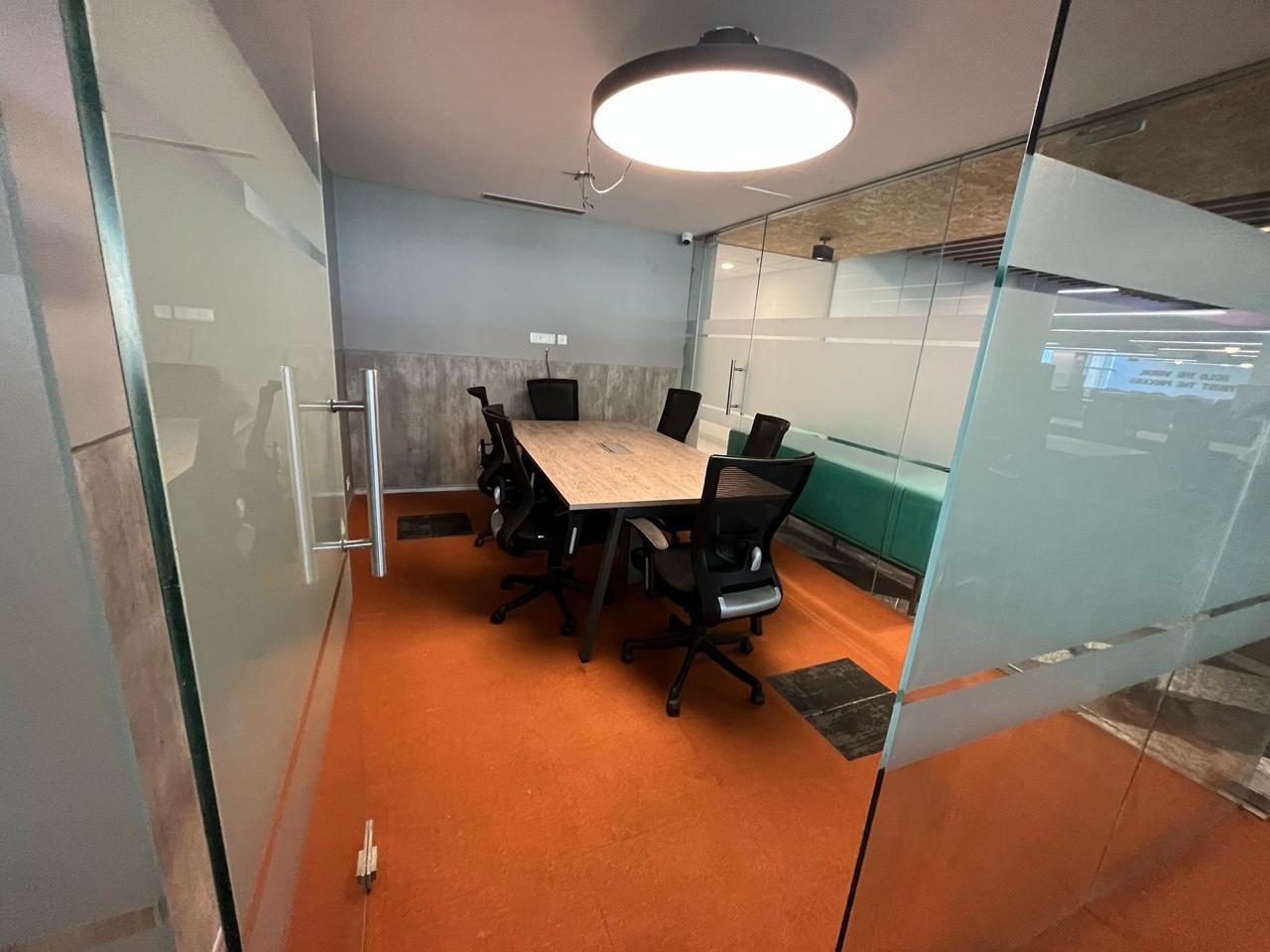 Glass-walled meeting room with orange carpet